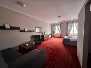 a hotel room with a bed and a couch and a chair at Pension U Jakuba in Olomouc