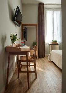 Dormitorio con escritorio, cama y TV en B&B My Way, en Florencia