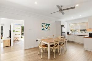 a kitchen and dining room with a table and chairs at Abode Callala Beach Jervis Bay - 100m to Beach! in Callala Beach