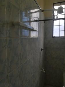 a bathroom with a shower with a glass door at Cozy Apartment - Nyali Mombasa in Mombasa