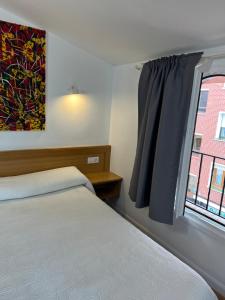 巴拉卡爾多的住宿－宙斯旅館，一间卧室设有一张床和一个窗口