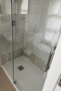 um chuveiro com uma porta de vidro e um WC em Pensión Zeus em Barakaldo