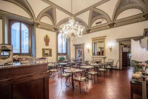 a dining room with tables and chairs and a chandelier at Hotel Martelli in Florence
