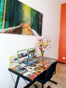 una mesa con cuadros y una pintura en la pared en Fiori e Frutti - Appartamento Economy, en Almese