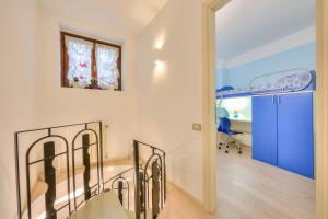 Habitación blanca con escalera y puerta azul en Barbarano House - near beach - Happy Rentals, en Saló