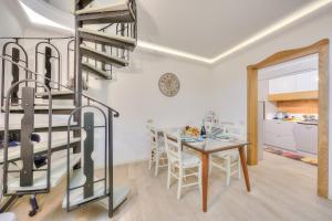 cocina y comedor con escalera de caracol y mesa en Barbarano House - near beach - Happy Rentals, en Saló