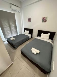 2 Betten in einem kleinen Zimmer mit Handtüchern darauf in der Unterkunft Modern City Center Apartment Saripolou 2 in Limassol
