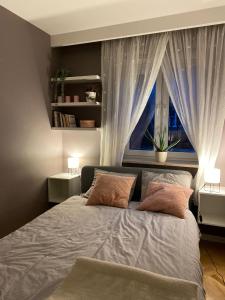 um quarto com uma cama com duas almofadas e uma janela em Apartament z tarasem przy parku em Varsóvia