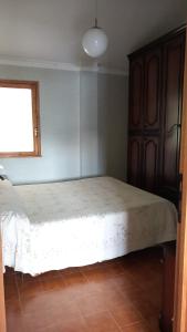 1 dormitorio con 1 cama en una habitación con ventana en La casa del lago, en Valle Verde