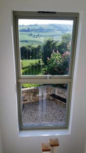 a window in a room with a view of a garden at The Gables - Spacious house, picturesque views & free parking in Bath