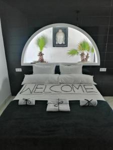 a bedroom with a bed with a welcome sign on it at Pinar Suites Loft in Torremolinos