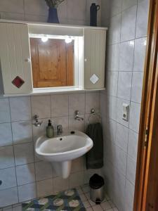 ein Badezimmer mit einem Waschbecken und einem Medizinschrank in der Unterkunft Erdőszélén Házikó Vendégház in Kehidakustány
