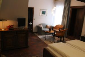 a living room with a bed and a tv and a couch at Haus am Wald in Eltmann
