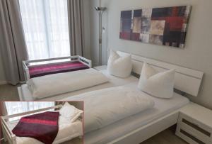Schlafzimmer mit einem Bett mit weißer Bettwäsche und Kissen in der Unterkunft Apartment Residenz am Balmer See Wohnung 44 mit Wellnessbereich in Balm