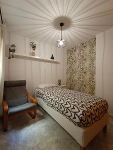 ein Schlafzimmer mit einem Bett und einem Stuhl in der Unterkunft La Fuente in El Paso