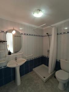 a bathroom with a sink and a toilet and a mirror at La Fuente in El Paso