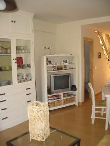 a living room with a tv in a white cabinet at ADOSADO FAMILIAR in Huelva