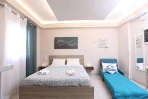 a bedroom with a bed and a blue chair at Arcade Game House-Luxury studio in Corfu Town in Agios Rokkos
