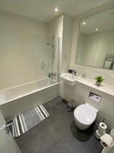 a bathroom with a tub and a toilet and a sink at Snapos Apartments - Platform A in Bedford