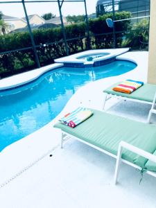 einen Pool mit zwei Liegestühlen neben einem Pool in der Unterkunft Florida Ridge Villa in Davenport