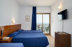 a hotel room with a blue bed and a balcony at Medplaya Hotel Vistamar Costa Dorada in Hospitalet de l'Infant