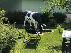 eine Statue einer Kuh, die auf einem Stuhl steht in der Unterkunft Hôtel Le Chinfrey in Les Gets