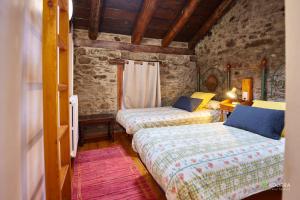 a bedroom with two beds in a stone building at Chalet Font in Soldeu