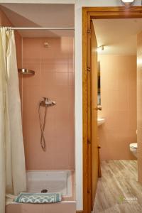 a bathroom with a tub and a shower with pink tiles at Chalet Font in Soldeu