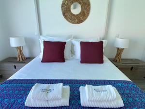 1 dormitorio con 1 cama con 2 toallas en Cairnvillas: Villa Terra C39 - Luxury Villa with Private Swimming Pool near Beach en Aljezur