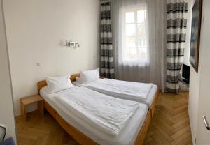 a bedroom with a bed with white sheets and a window at Gasthaus zur Sonne in Rhodt unter Rietburg +4 photos
