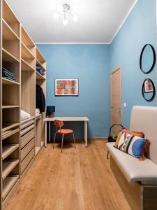 Habitación con paredes azules, escritorio y sofá. en Beautiful Room in Heart of Madrid, en Madrid