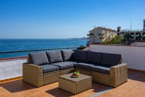Seaview terrace with pool in Carvajal Ref 103 في Torremuelle: أريكة على شرفة مع المحيط في الخلفية