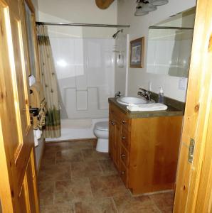y baño con lavabo, aseo y espejo. en The Hideaway Hostel en Island Park