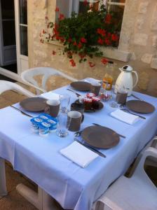 uma mesa com uma toalha de mesa azul e pratos em Les Rainettes em Coye-la-Forêt