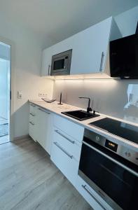a white kitchen with a stove and a microwave at Ferienwohnung am Hengsteysee in Herdecke