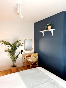 1 dormitorio con una pared azul, una silla y una mesa en 'Bridgewater' at stayBOOM, en Morecambe