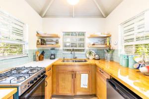 una cucina con armadi in legno, piano cottura e lavandino di Dreamy Cottage in Grace Bay with BBQ and Bikes Included a Providenciales