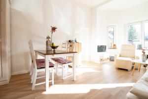 a white dining room with a table and chairs at Burg Rotraut #2 in Ostseebad Sellin