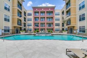 einen Innenhof mit einem Pool vor einem Gebäude in der Unterkunft Modern Condo near Texas Medical Center w Free Parking in Houston
