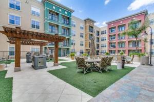 un patio con mesa, sillas y edificios en Modern Condo near Texas Medical Center w Free Parking en Houston