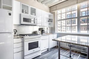 a kitchen with white appliances and a table at Loop 1BR w Gym Roof nr Millennium Park CHI-387 in Chicago