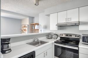 a white kitchen with a sink and a stove at Streeterville Studio w pool gym nr Navy Pier CHI-787 in Chicago