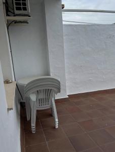 un banco blanco sentado en una habitación con ventana en APARTAMENTO EN LOS GALLOS en Chiclana de la Frontera