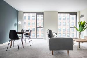 シカゴにあるLoop 1BR w Pool Gym nr the L Riverwalk CHI-242のソファとテーブルと椅子のあるリビングルーム