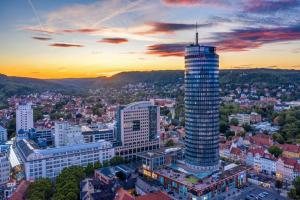 Blick auf eine Stadt mit einem hohen Gebäude in der Unterkunft FAIR RESORT All Inclusive Wellness & Sport Hotel Jena in Jena