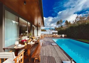 une terrasse avec une table et une piscine dans l'établissement Casa das Bolotas, à Viana do Castelo