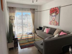 a living room with a couch and a painting on the wall at Casa Balcones - Benalmadena Pueblo in Benalmádena