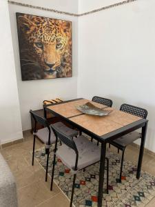 a dining room table and chairs with a painting on the wall at Casa Balcones - Benalmadena Pueblo in Benalmádena