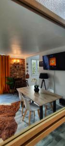 a living room with a wooden table and a tv at Appartement lumineux cosy et calme proche du métro in Créteil