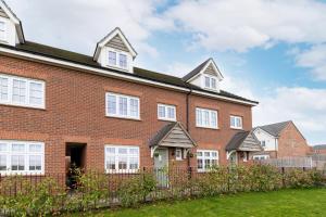 a red brick building with white windows and a fence at Charming City Fields Retreat - Off Road Parking, Self Check-in, King Size Beds, En-suite Rooms, Excellent Wakefield & Leeds City Centre Access - Contractors Welcome in Wakefield